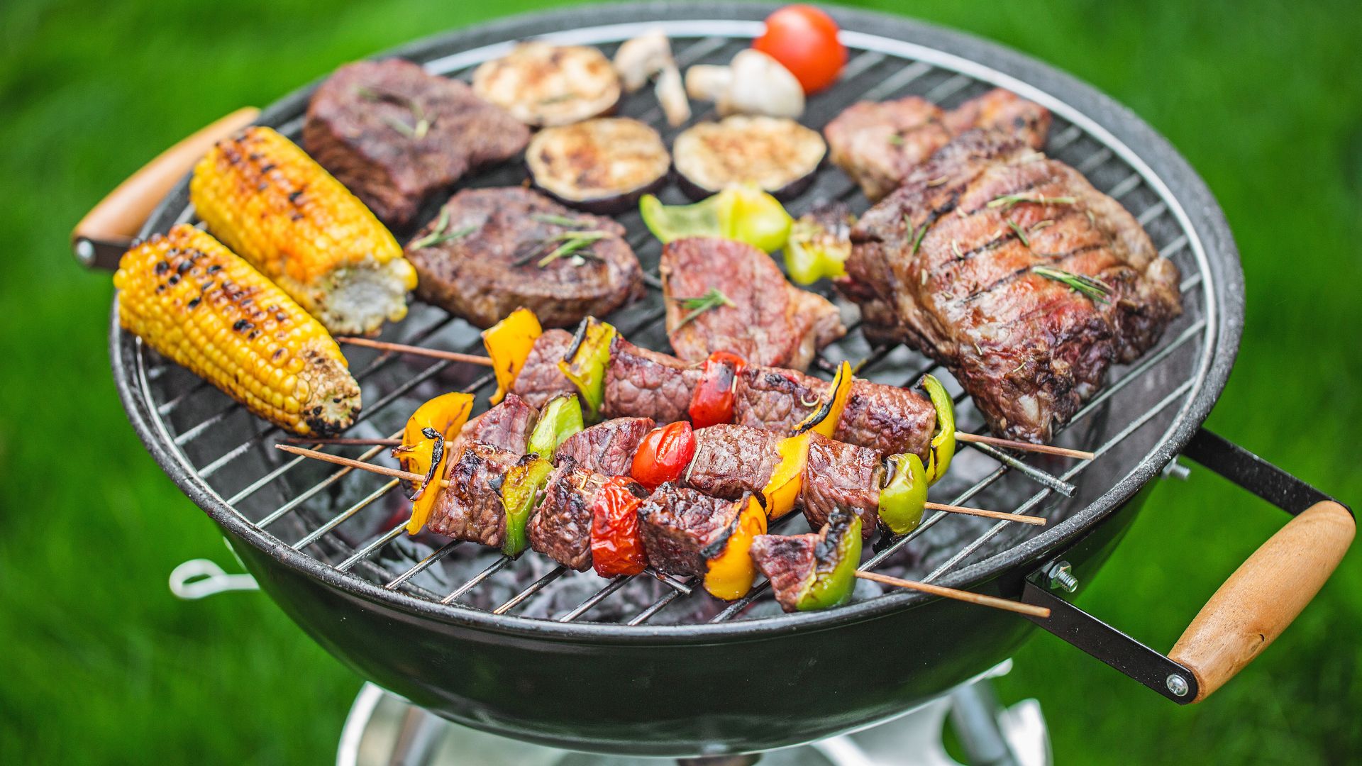 Ein Grill mit verschiedenen Fleischsorten und Gemüse, perfekt für ein Sommerfest.