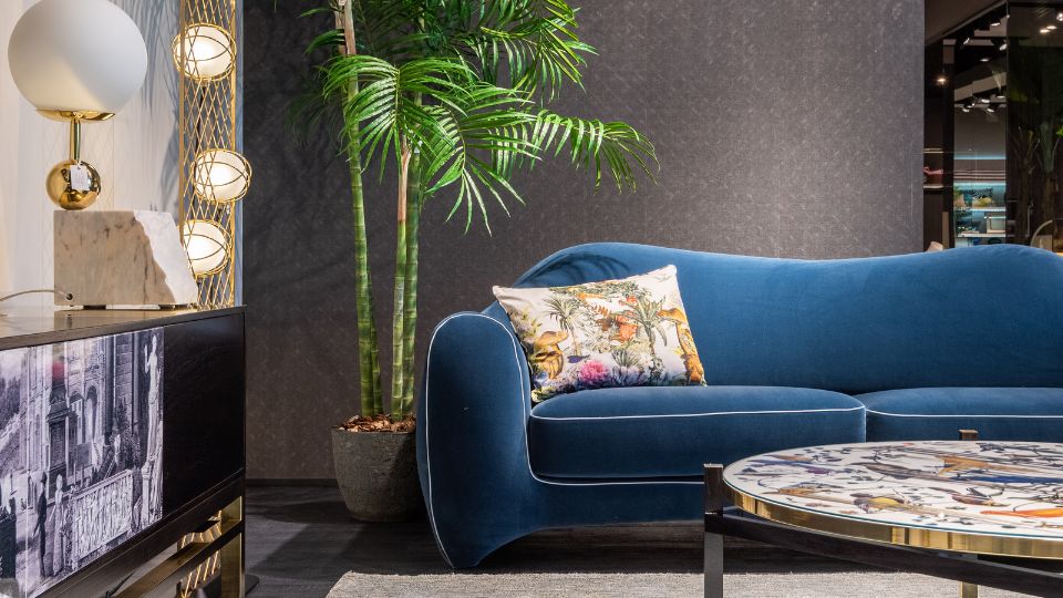 Ein stilvolles, blaues Sofa mit einem bunten Kissen in einem modernen Raum.